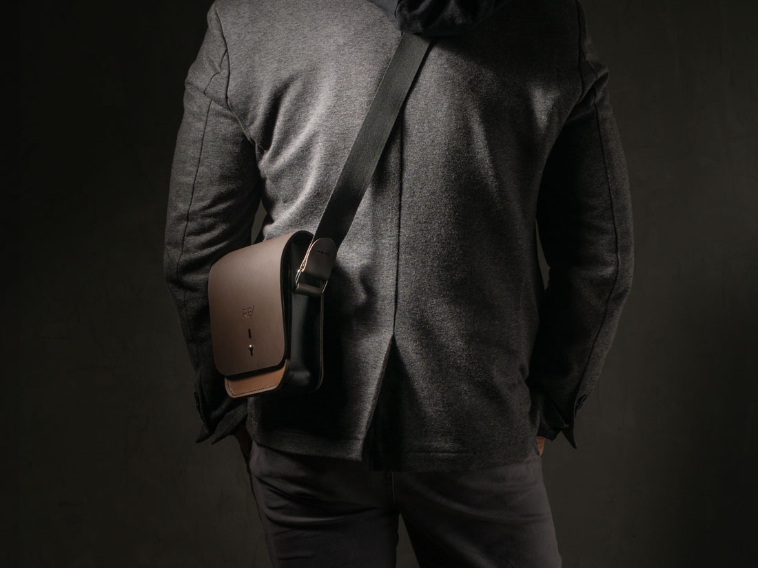 Bolsa Cube em couro bicolor marrom e preto usada a tiracolo como uma shoulder bag.