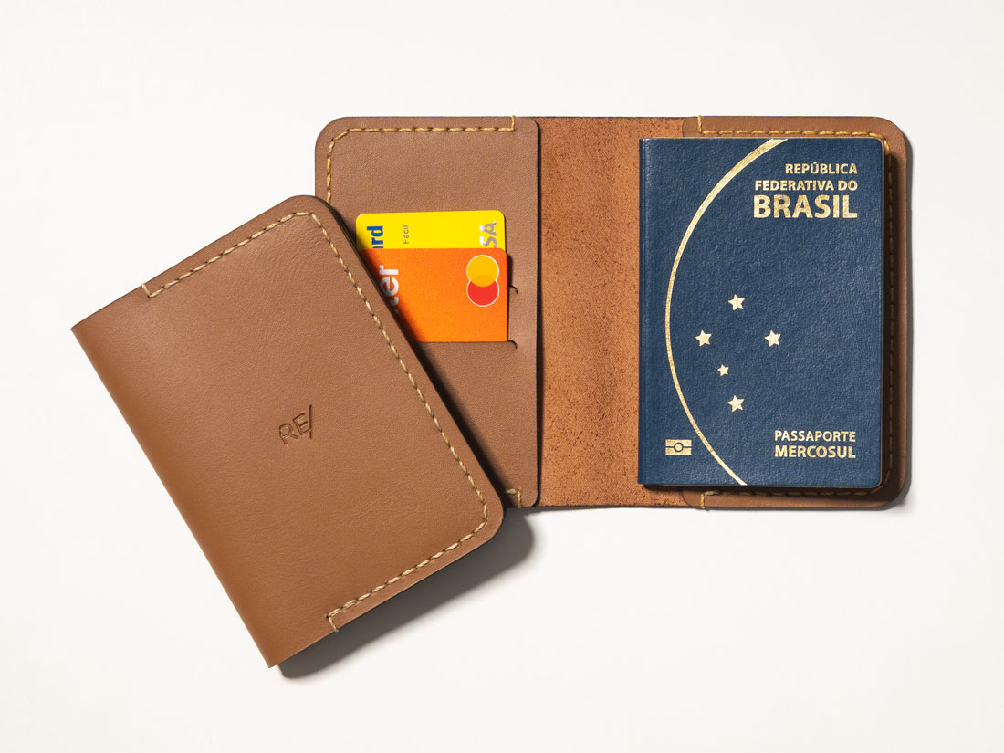 Capa para passaporte feita em couro caramelo, com slots para cartões de crédito e débito, bolsos para dinheiro em espécie e documentos.