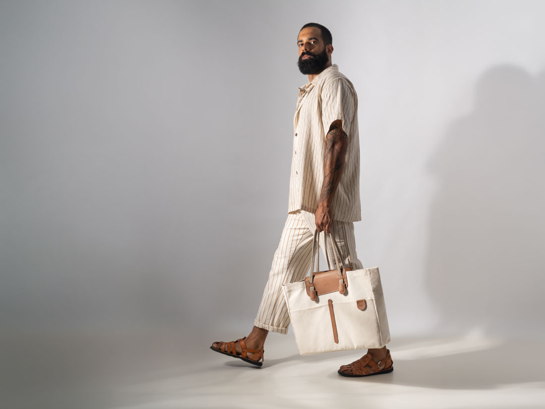 Uma maxi bolsa masculina de ombro, minimalista e elegante, feita em couro bovino legítimo e lona de algodão de alta gramatura.