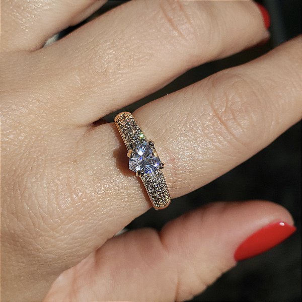 ANEL DOURADO MODELO SOLITÁRIO MICROCRAVEJADO COM ZIRCÔNIAS BRANCAS E PEDRA DE CORAÇÃO NO MEIO