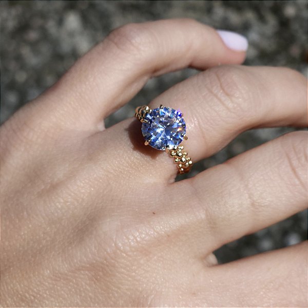 ANEL DOURADO COM DETALHES NO ARO E UM SOLITARIO GRANDE