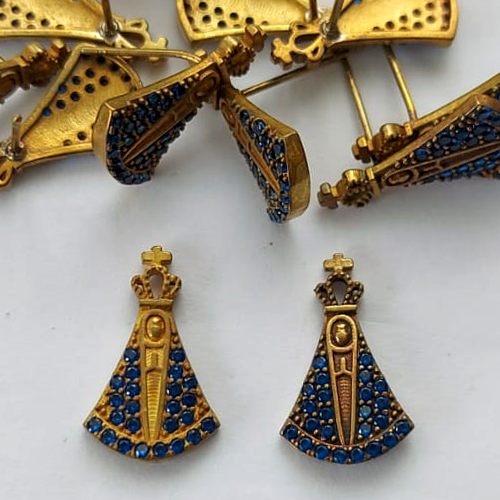 BRINCO NO BRUTO PRONTO PARA O BANHO -  (CX.136)  BRINCO DE PINO NOSSA SRA APARECIDA CRAVEJADA EM MICROS ZIRCÔNIAS AZUIS 17MM - PESO: 1,6GR - COMPOSIÇÃO: LATÃO / ZIRCÔNIA - BRU15637