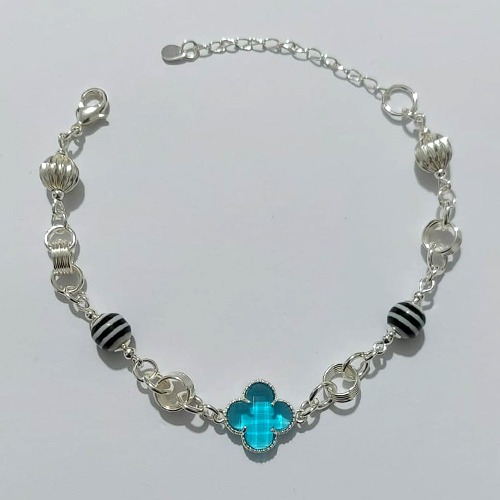 PULSEIRA FOLHEADA A PRATA COM 50 MILÉSIMOS + VERNIZ DIAMOND - PULSEIRA COM ELEMENTOS VAZADOS, ESFERAS LISTRADAS E TREVO TIPO VAN CLEEF AZUL - TAMANHO: 18CM + EXTENSOR - PRA1007