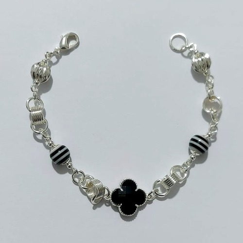 PULSEIRA FOLHEADA A PRATA COM 50 MILÉSIMOS + VERNIZ DIAMOND - PULSEIRA COM ELEMENTOS VAZADOS, ESFERAS LISTRADAS E TREVO TIPO VAN CLEEF PRETO - TAMANHO: 18CM - PRA1008