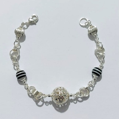 PULSEIRA FOLHEADA A PRATA COM 50 MILÉSIMOS + VERNIZ DIAMOND - PULSEIRA COM ELEMENTOS VAZADOS, ESFERAS LISTRADAS E ESFERA VAZADA - TAMANHO: 18CM - PRA1011
