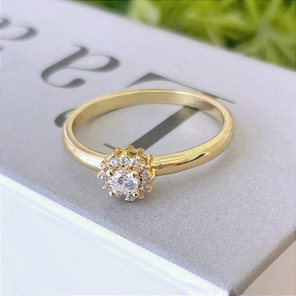 Anel Flor com Borda Cravejada e Zirconia Cristal Pequena Central Folheado a ouro 18K