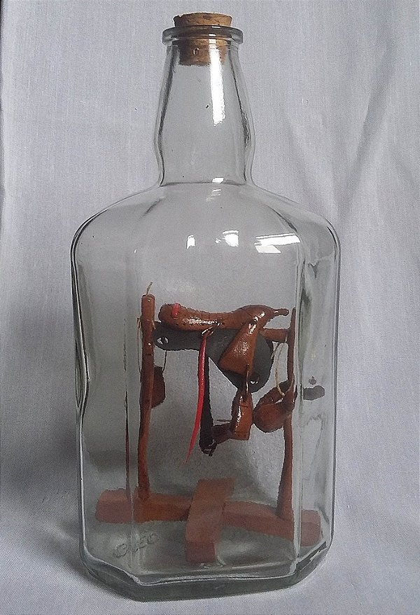 Arreio ou cela em litro de uísque. artesanato de madeira montado dentro do litro sem corte.