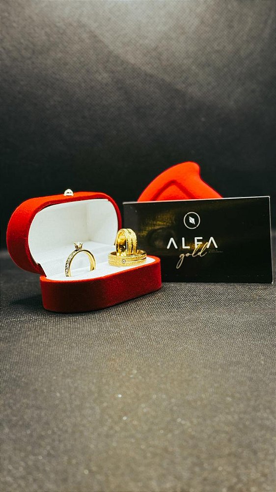 Par de alianças douradas, diamantadas com friso e zircônia.