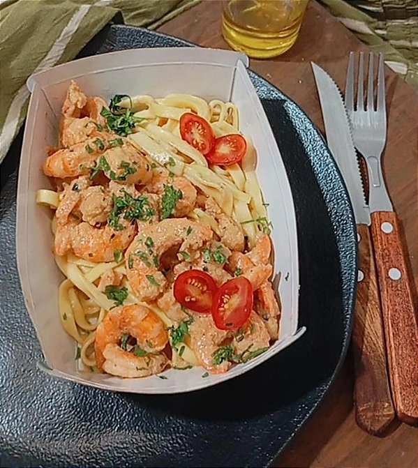 Camarões salteados acompanhados de fettuccine artesanal ao molho de sálvia.