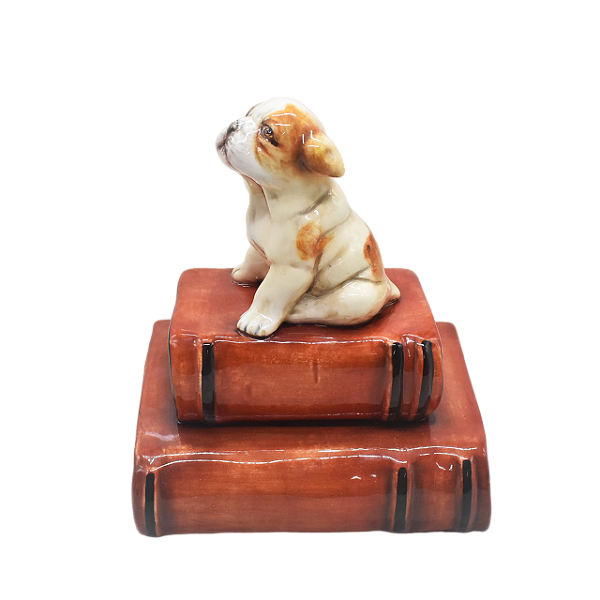 Enfeite filhote de bulldog sentado em dois livros