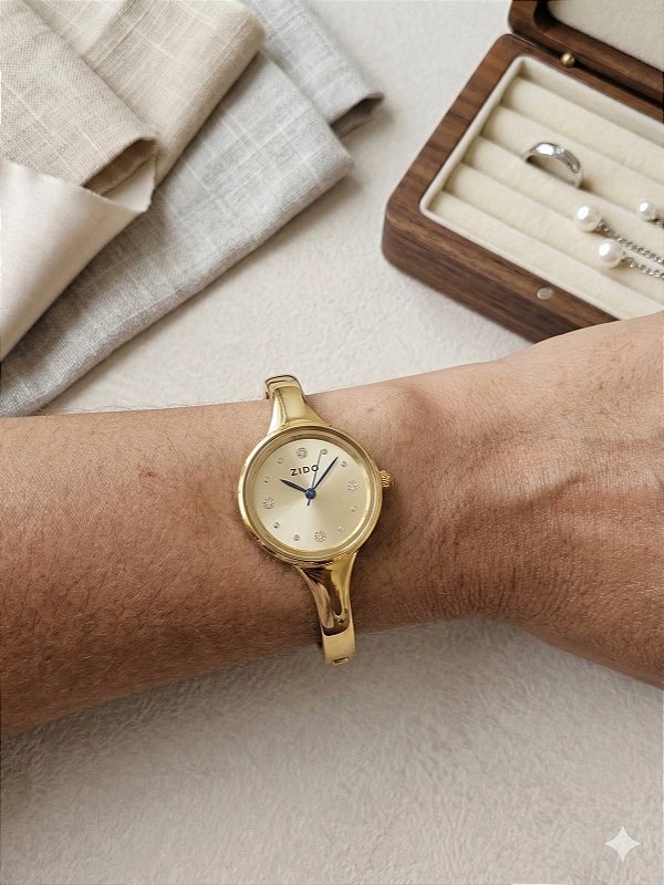Relógio bracelete dourado fundo dourado