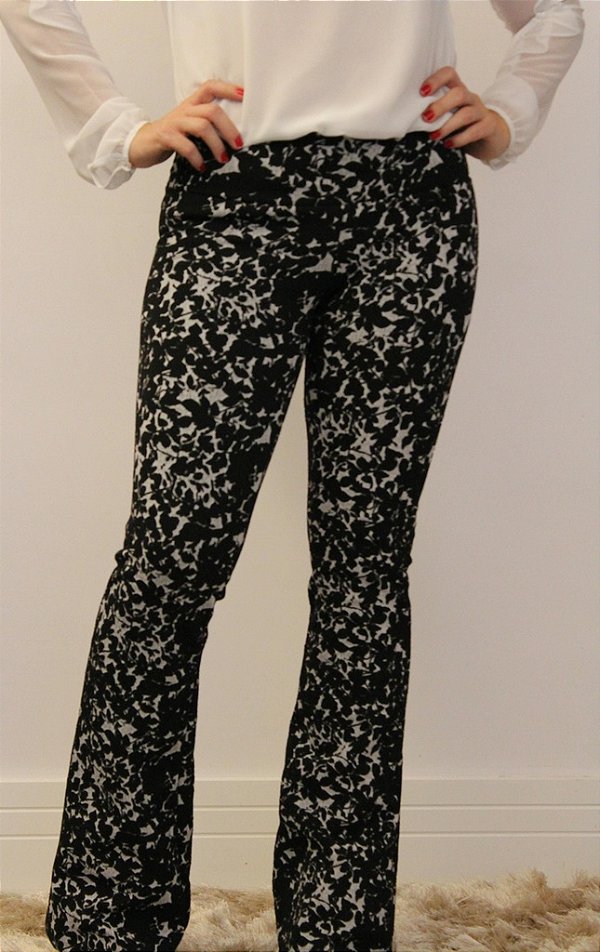 Calça feminina modelagem flare em tecido jacquard preto e branco com estampa de folhas