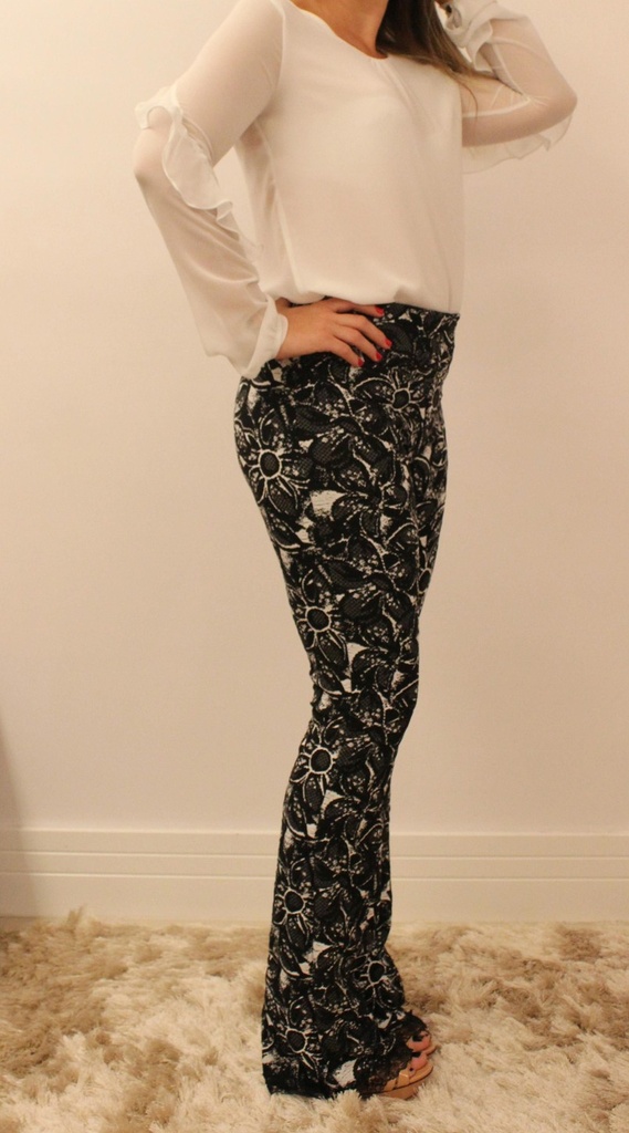 Calça feminina modelagem flare em tecido jacquard com estampa florida e renda preta na barra
