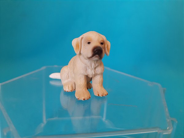 Miniatura de vinil Schleich de filhote Golden Retriever sentado 5 cm de comprimento e 3 cm de altura