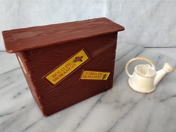 Prateleira de plástico e regador branco da Confeitaria da moranguinho