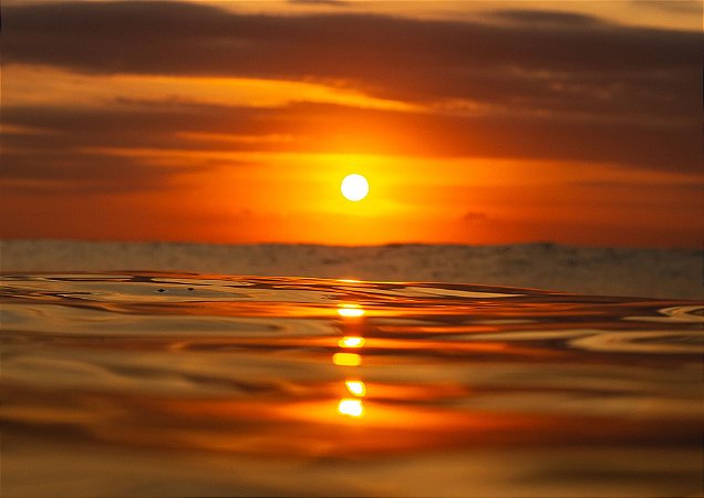 Nascer do sol e um belo céu laranja em fotografia aquática