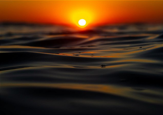 Nascer do sol com um belo céu laranja em fotografia aquática