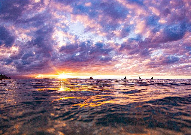 Pôr do sol com surfistas pegando onda