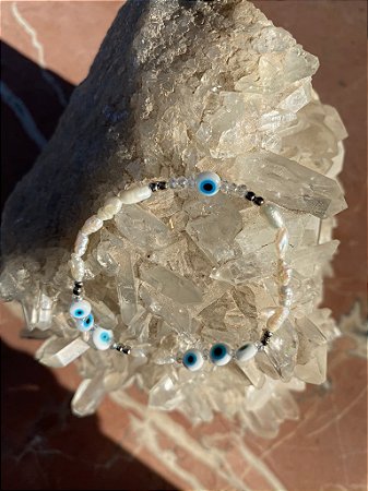 Pulseira mista de pérolas barrocas pequenas,cristais tchecos lapidados translúcidos e olho grego,com detalhes de metal banhado.