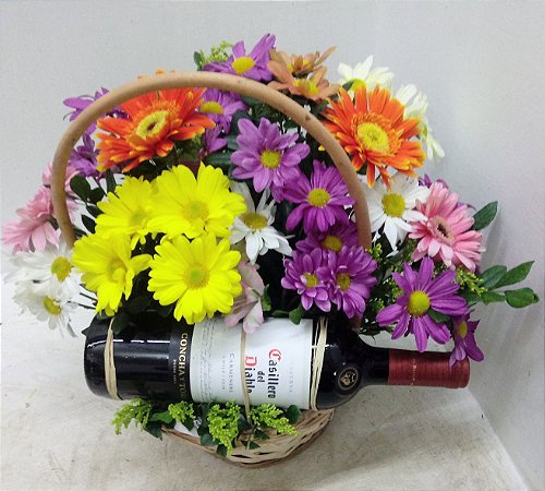 Cesta de flores do campo com garrafa de vinho