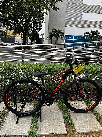BICICLETA MTB ARO (29) OXS ALUMINIO 21 VELOCIDADES FREIO DISC MECÂNICO 15 (P) PRETO/LARANJA/VERMELHO