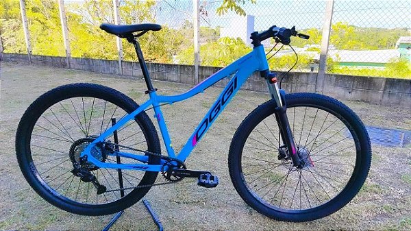 BICICLETA MTB ARO (29) OGGI FLOAT 5.0 SHIMANO ESSA 8 VELOCIDADES FREIO DISC HIDRÁULICO TAMANHO 15 (P) COR AZUL/PTO/ROSA