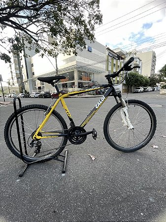 BICICLETA ARO (26) MASCULINA MTB CALOI SUPRA 21 VELOCIDADES (3X7) FREIOS V-BRAKE COR PRETO/AMARELO (USADA)