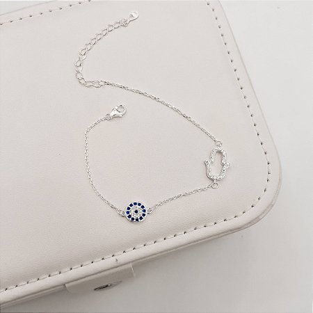 Pulseira entremeios mão vazada e olho grego cravejados