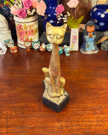 Escultura em bronze representando um delicado gatinho.