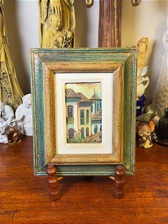 Quadro com moldura em madeira patinada.