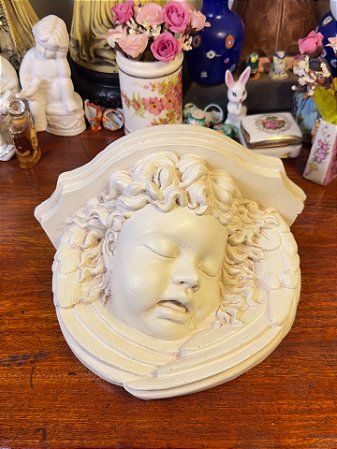 Peanha em resina delicadamente esculpida.