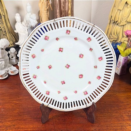 Prato fenestrado em porcelana com filete dourado.