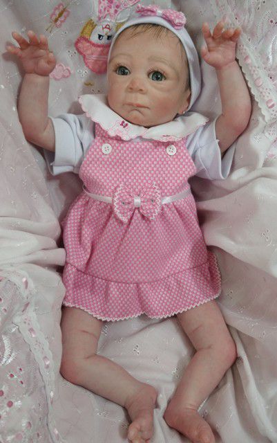 Bebê reborn menina com 50 cm e 1,36 kg. Cabelos pintados e enraizados no topo (combo). Acompanha vários acessórios