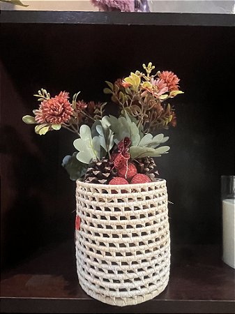 Cesto com flores rosas e folhagem verde