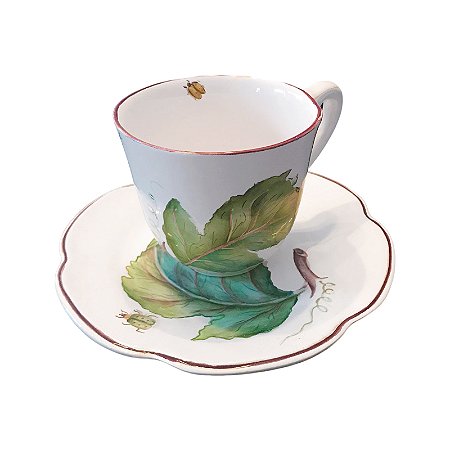 Xícara chá folhas com joaninha e borboleta