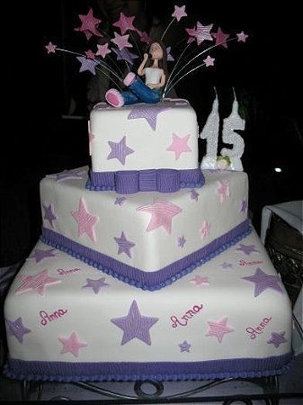 Um bolo com glacê rosa e roxo e uma estrela roxa no topo.