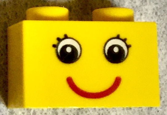 Tijolo 1x2 amarelo com desenho de olhos e cílios e sorriso vermelho