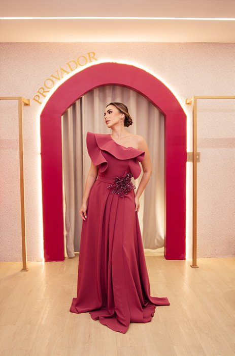 VESTIDO CREPE OMBRO UNICO FUCSIA FOLHO BABADO COM CINTO APLICAÇÃO DE FLOR ARAMADA