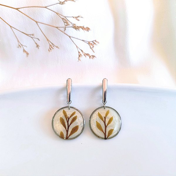 Brincos de raminho de folhas na moldura redonda