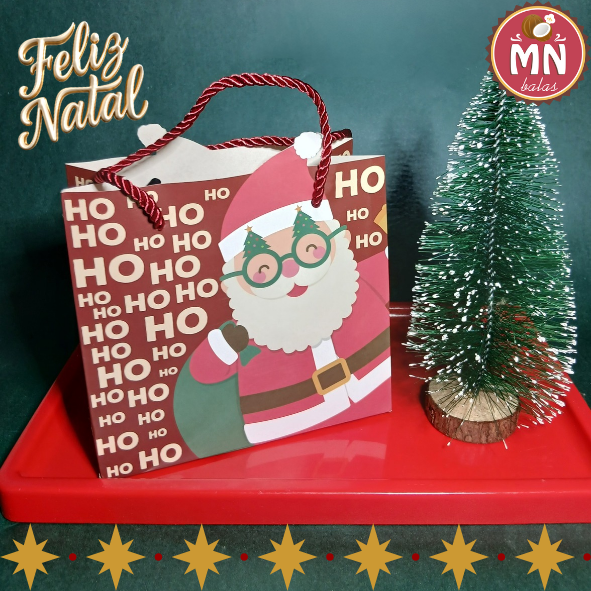 Unidade da sacolinha de presente de natal 15,5 cm x 7 cm x 14,3 cm com 15 balas recheadas de maracujá, limão e frutas vermelhas com cartão impresso de brinde