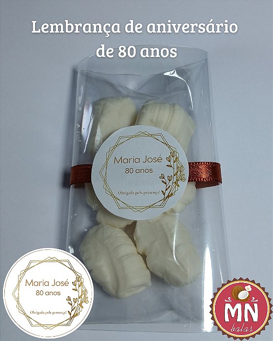 Unidade do saquinho adesivado com 6 balas de coco tradicionais, sem recheio, no tamanho normal fechados com fita de cetim número 2 com tag personalizada 3,5 cm aniversário de 80 anos