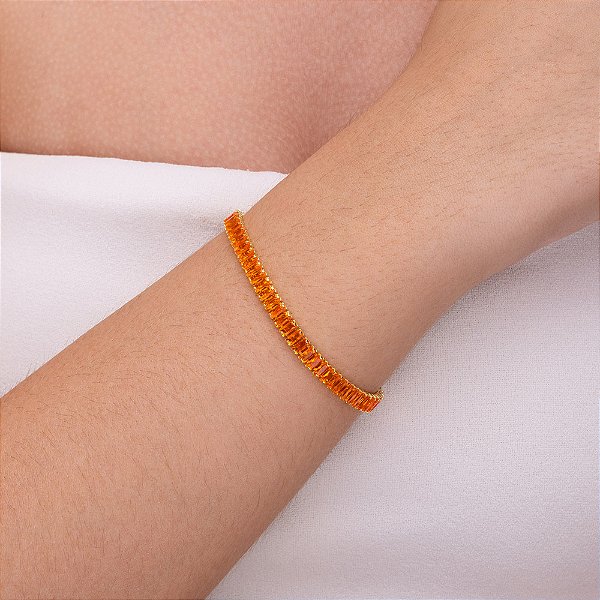 Pulseira rivieira em baguete com zircônia laranja folheada a ouro