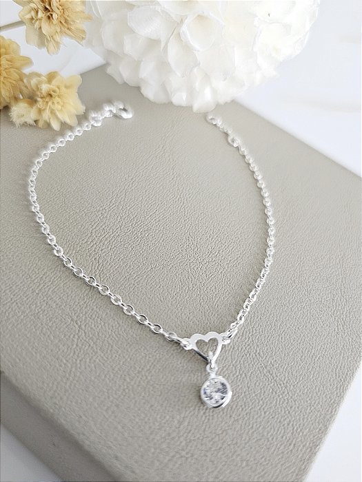 Pulseira com pingente coração vazado e ponto de luz de zircônia