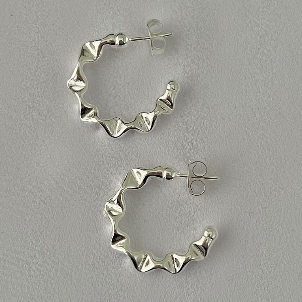 Argola meia lua ondulada G em banho de prata silver