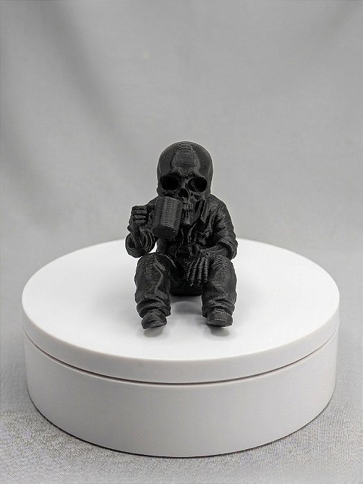 Caveira sentada com caneca na mão