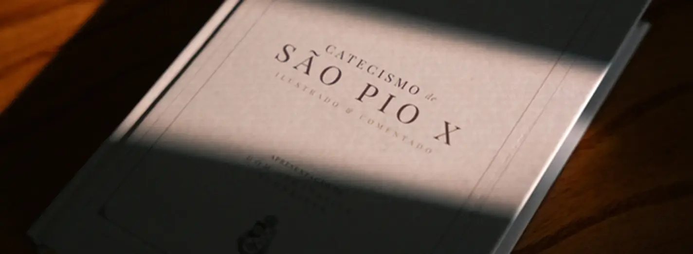 Capa do livro Catecismo de São Pio X sobre uma mesa