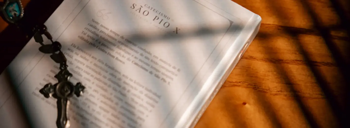 Verso do Catecismo de São Pio X com um terço sobre o livro