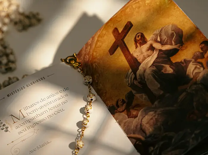 Livro aberto com terço sobre a página