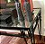 Antiga e grande mesa de apresentação, original, estilo inglês, em ferro forjado, detalhes na saia de recorte em ferro, detalhes nos pés, tampo em espelho, perfeito estado, pintado de preto, mede 1,75x65x80 cm altura - Imagem 2