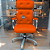 Cadeira Original Eames Presidente com Rodinhas Cromadas e Anti Risco Linha Capa em Madeira Escura ou Clara - Laranja - Imagem 1